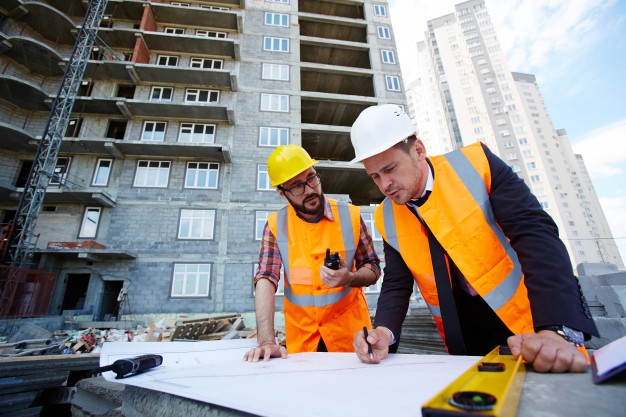 Personas revisando los planos en una construcción.