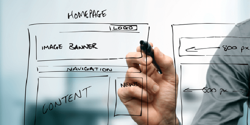 person's hand sketching a website