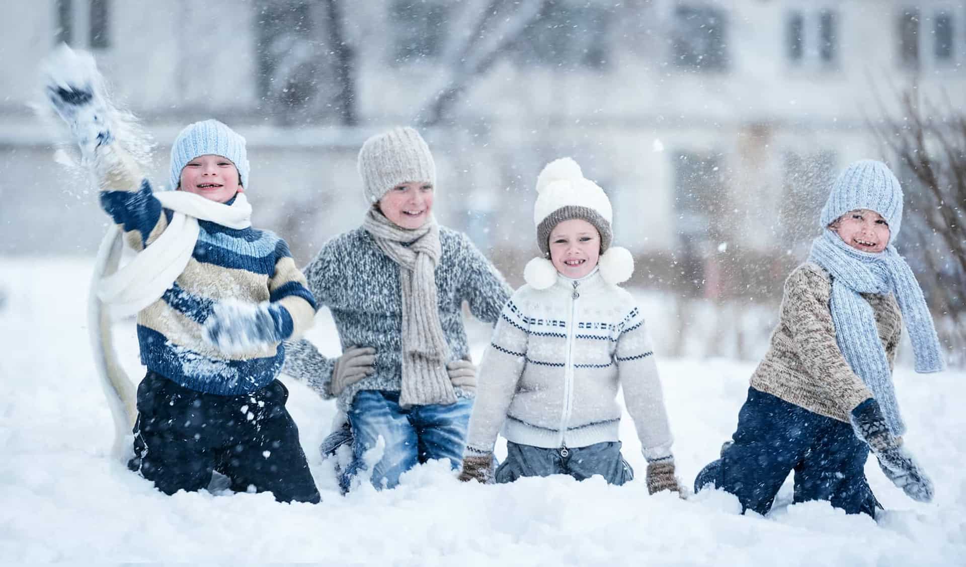 Preschool students having a snowball fight in the playground area.