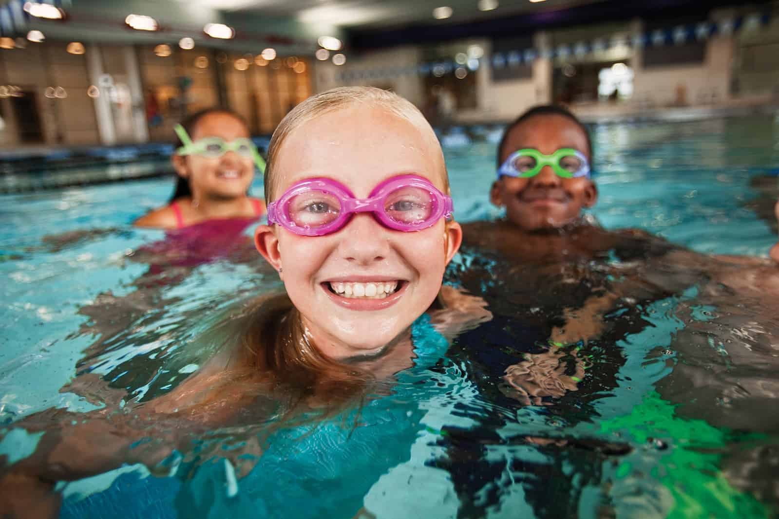 Girl swimming with two friends