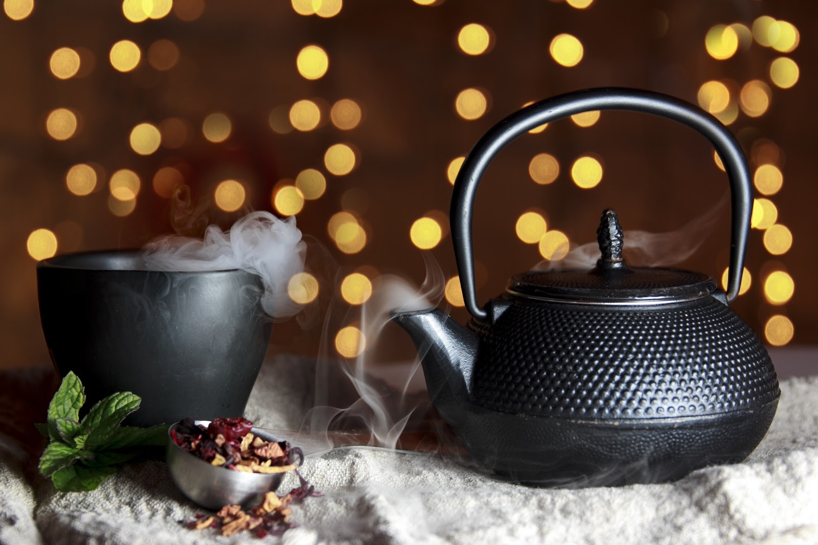 tea cup and kettle black steaming herbal tea