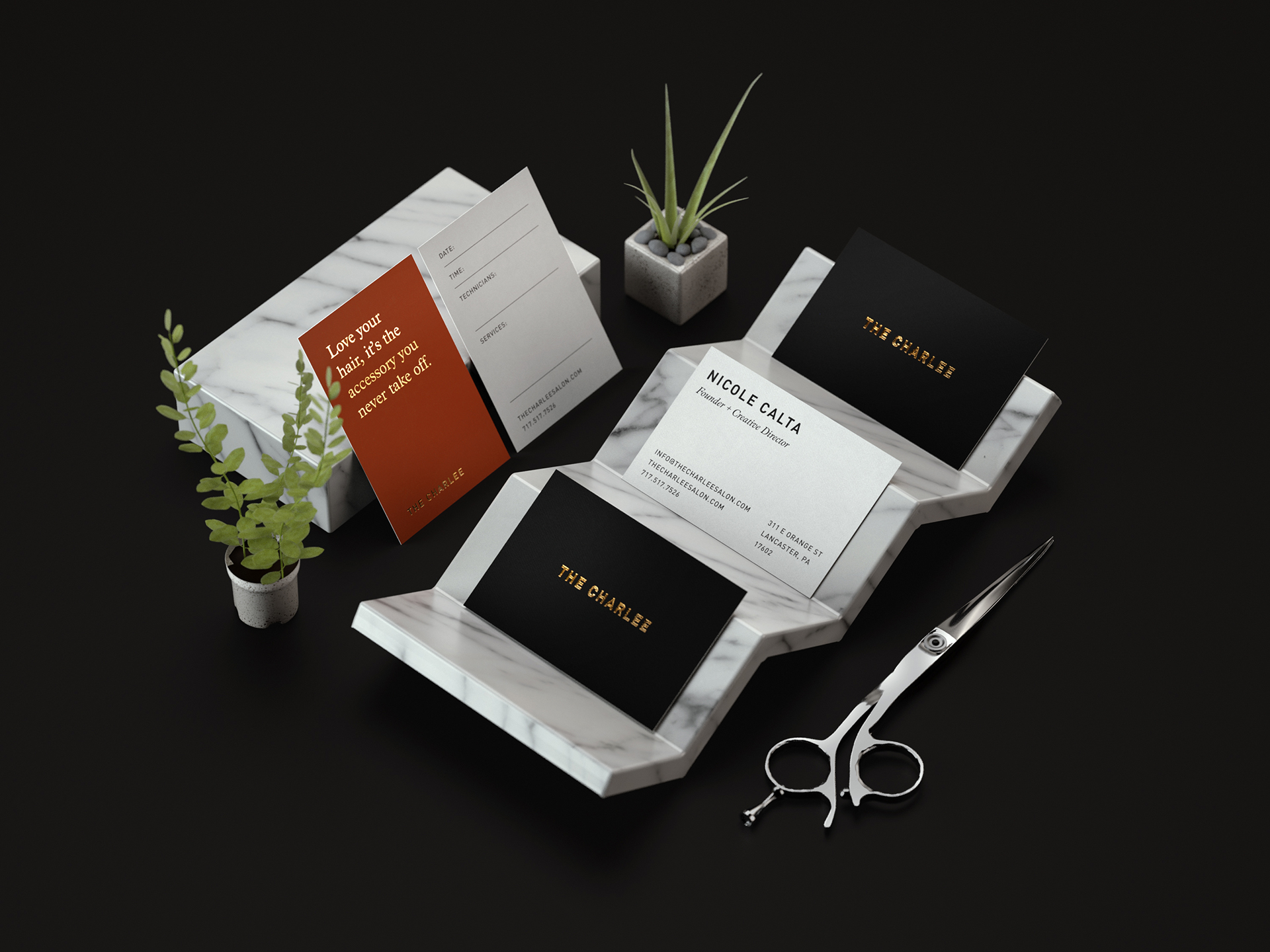Business and reservation cards with gold foil accents sitting on small pieces of marble