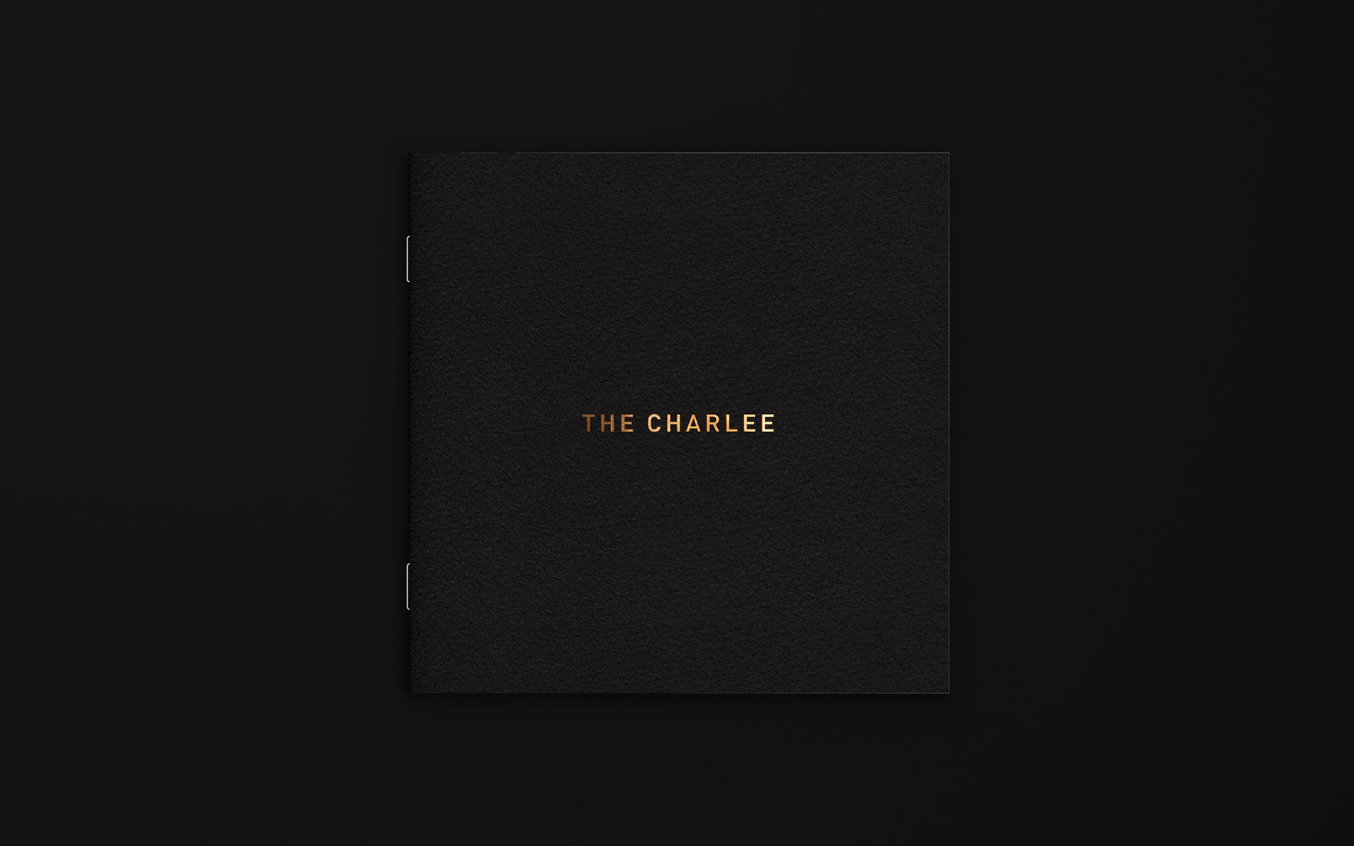 The Charlee salon's brochure cover with gold foil logo