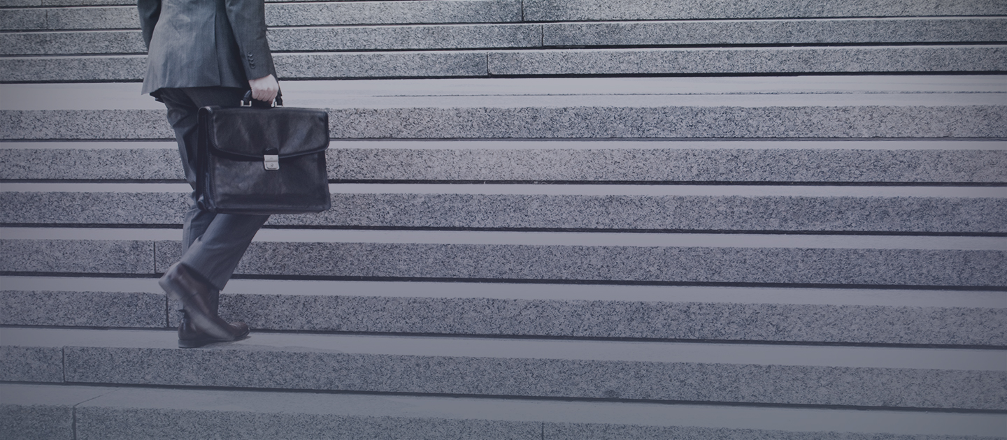 guy with laptop bag walking up stairs