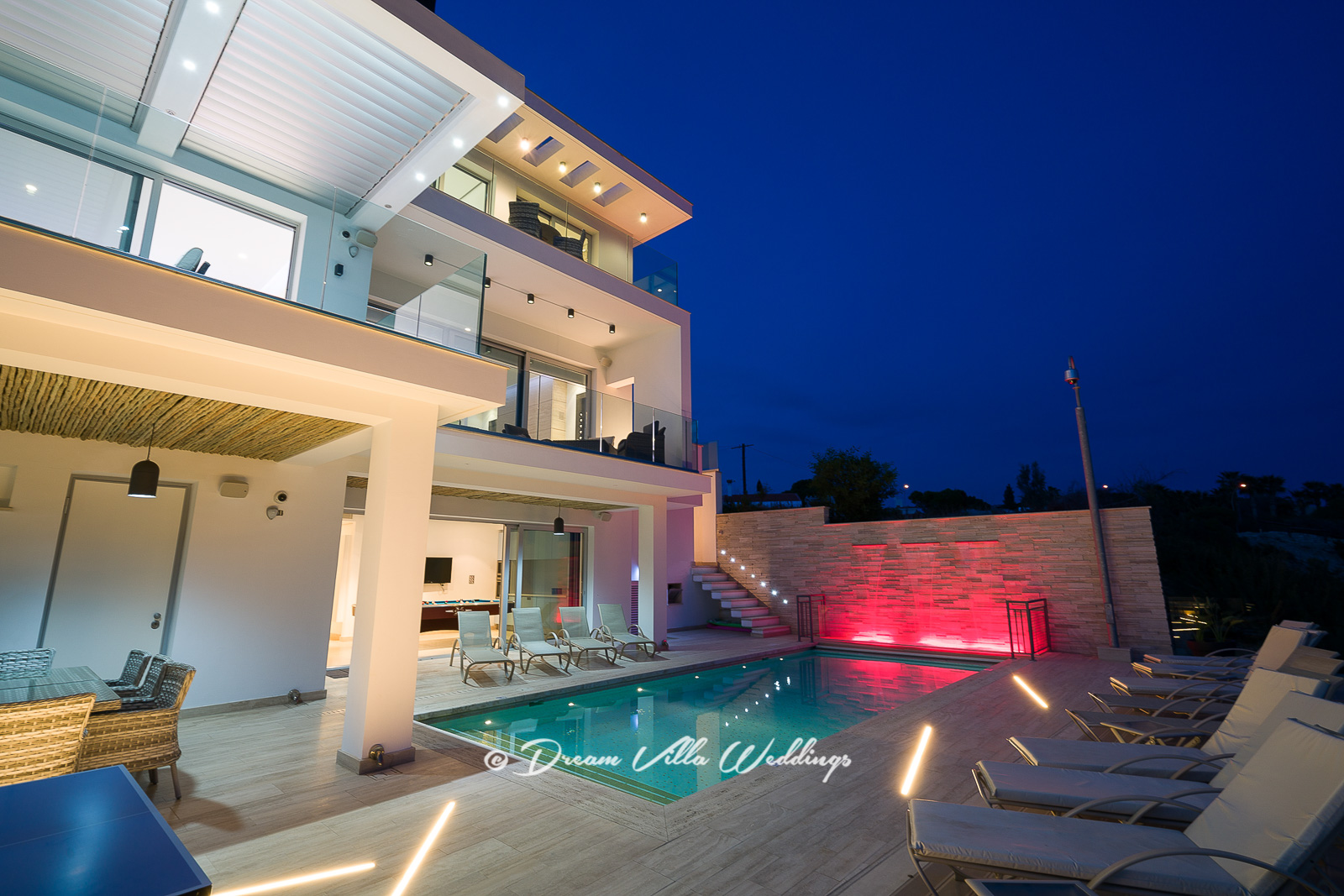 The pool and outside areas of the villa lit-up at night