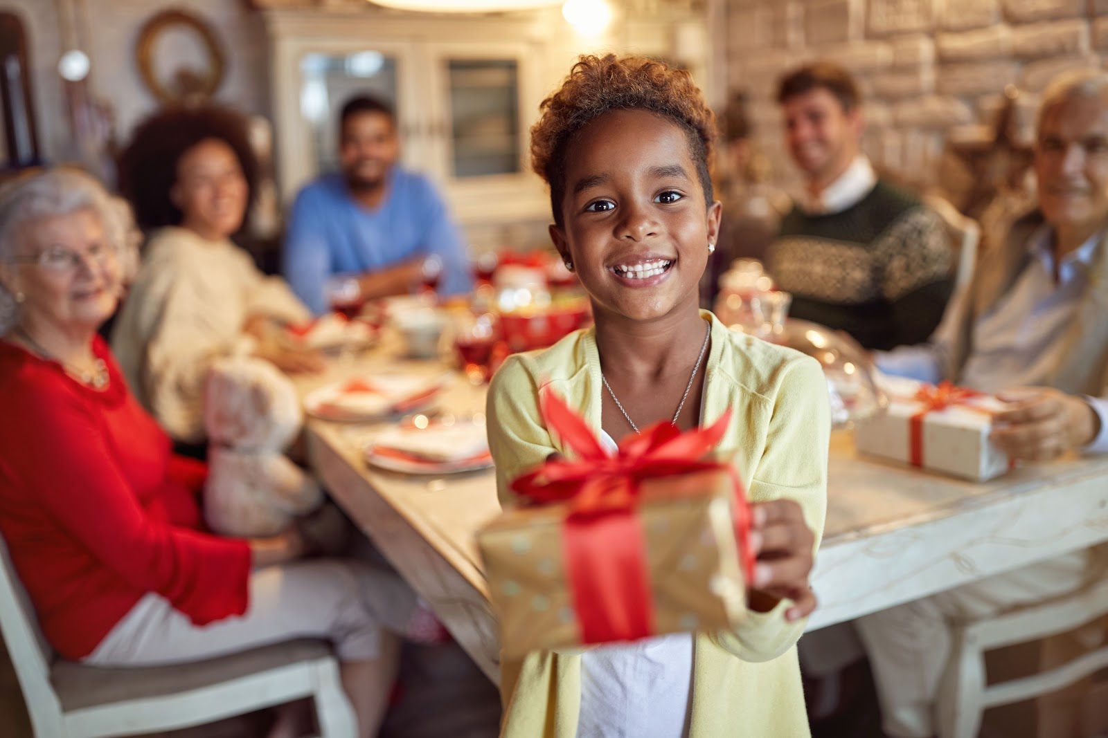 What is Giving Tuesday? Child holds wrapped gift toward camera