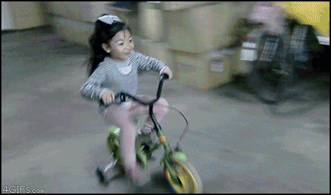 Young girl riding a bike GIF