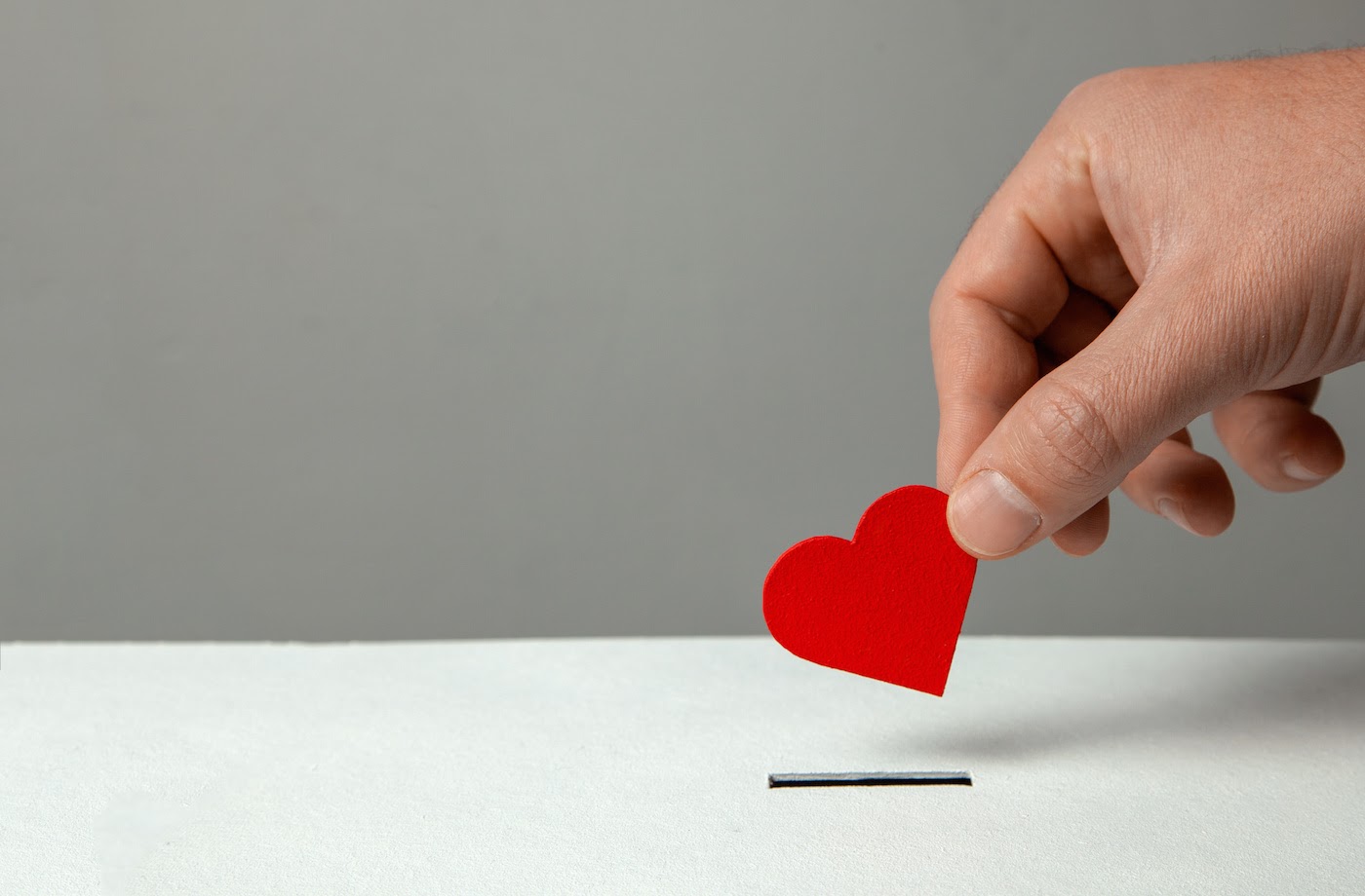 Man dropping a red heart inside box