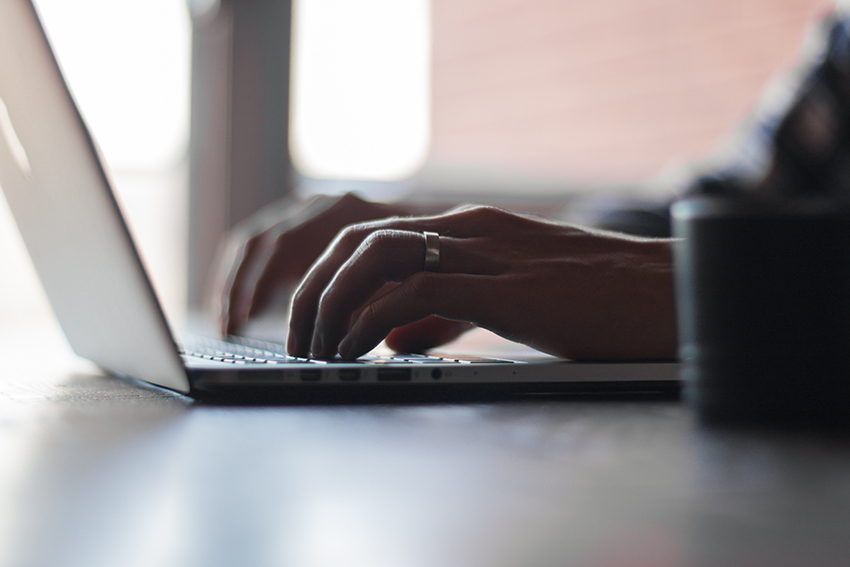 A person writing on a lap top