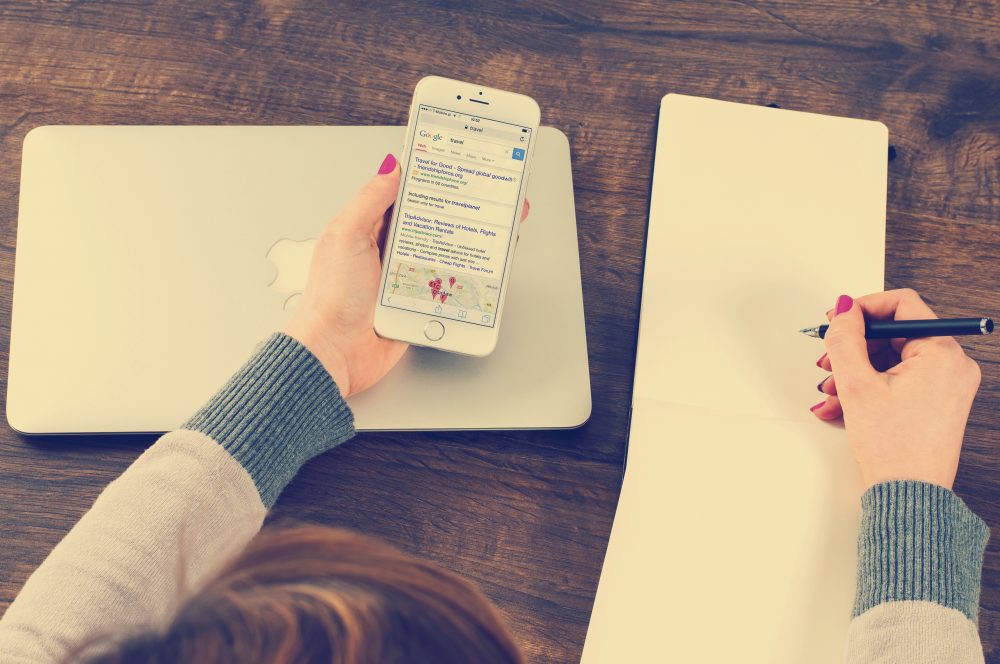 A person copying text to note pad from a mobile