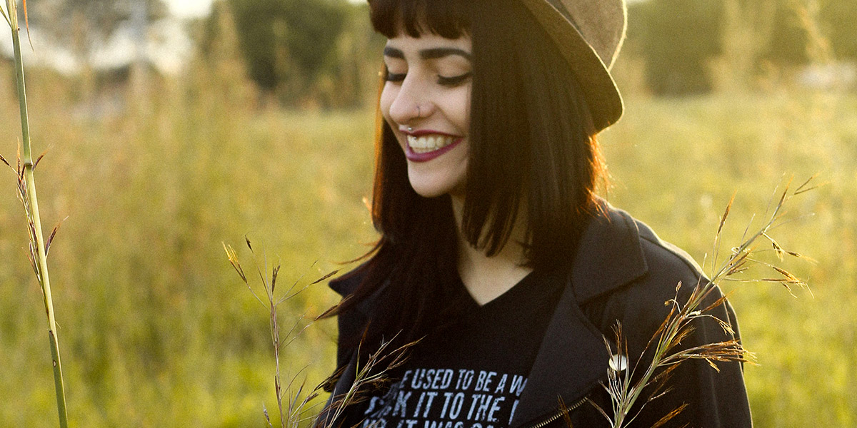 A happy person smiling in a sun lit feild