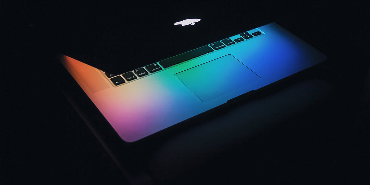 Partially opened laptop with multi color screen glow
