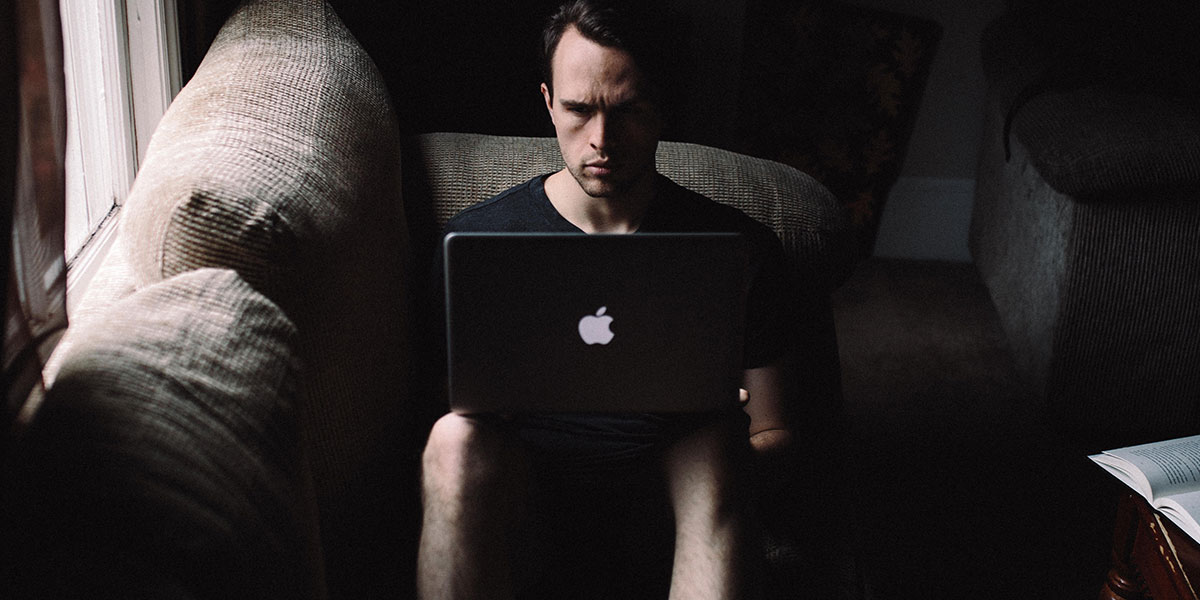 A person working on a laptop in a dark room