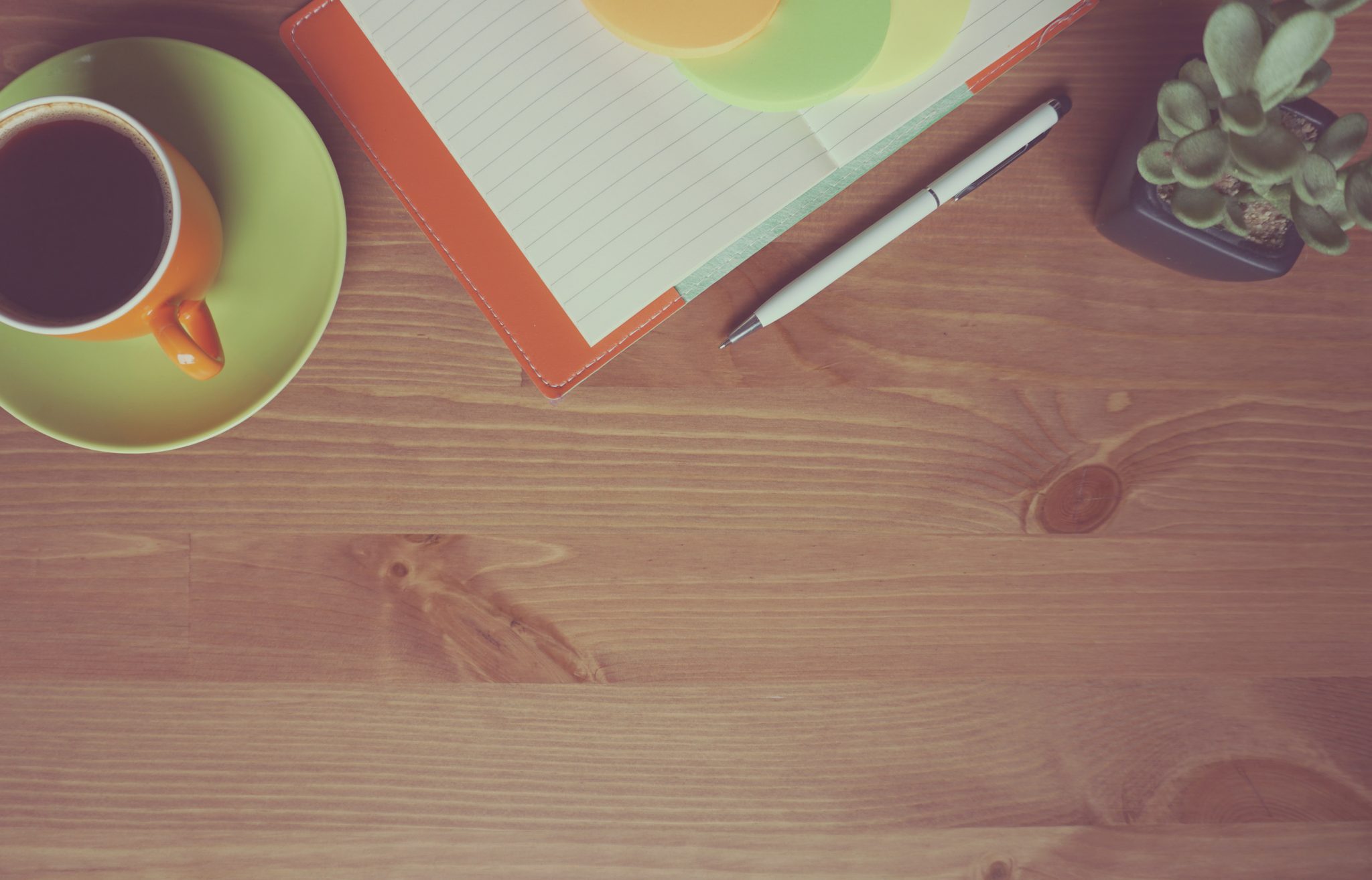 A table with a note pad and cup of coffee