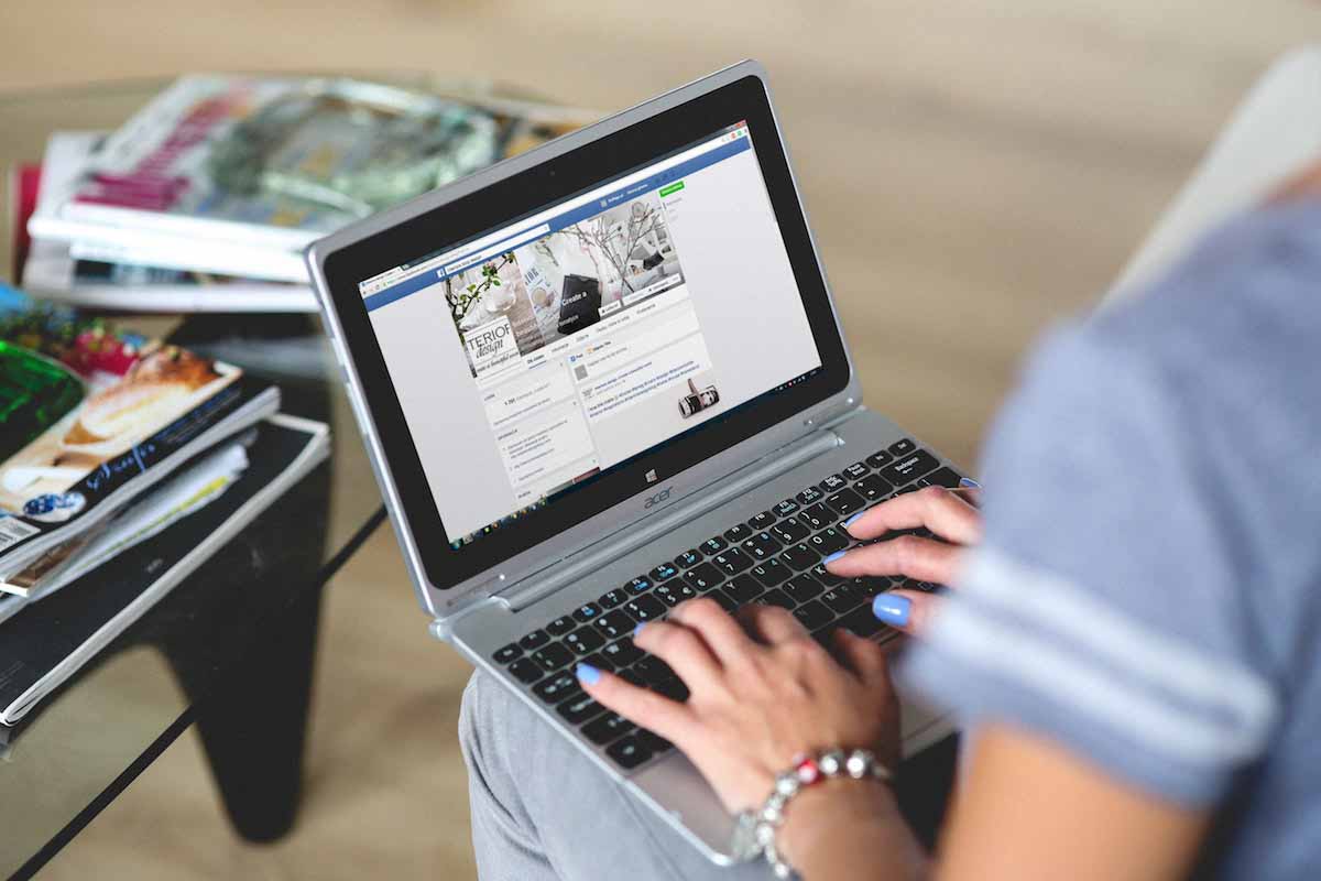 Woman looking at Facebook on her laptop