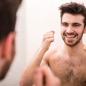 preventative dentistry man flossing teeth