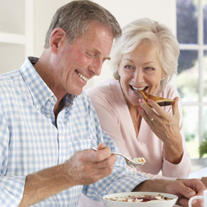elderly couple enjoying food with new dental bridge