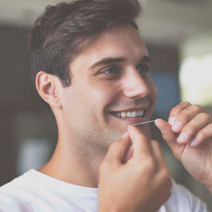 man flossing teeth to prevent gingivitis