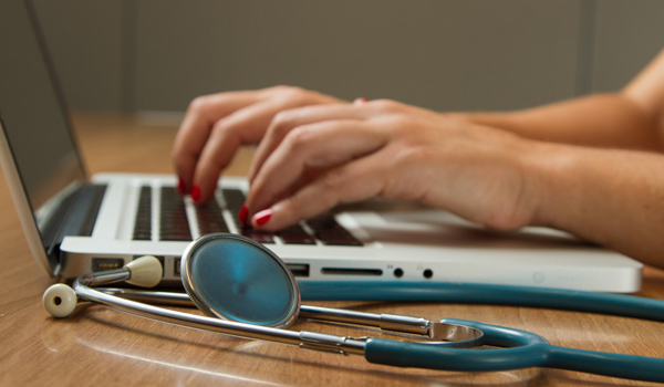 nurse typing on laptop