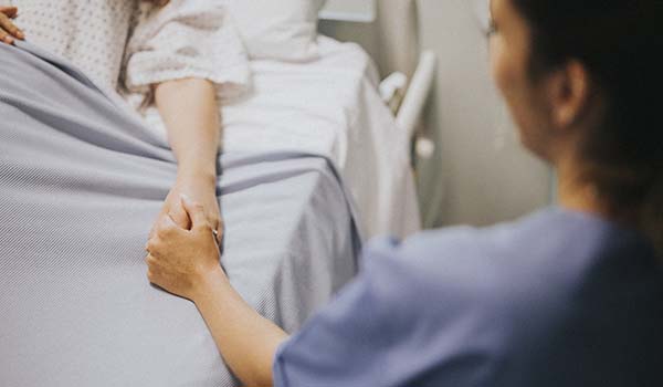 nurse holding patient's hand