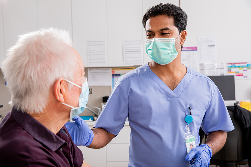 CareRev nurse in a mask talking to a patient