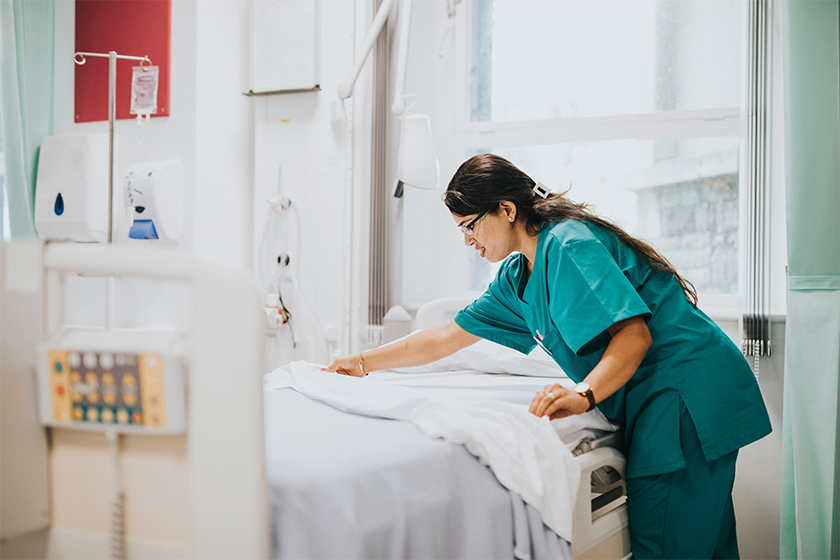 CareRev nurse making a patient's bed