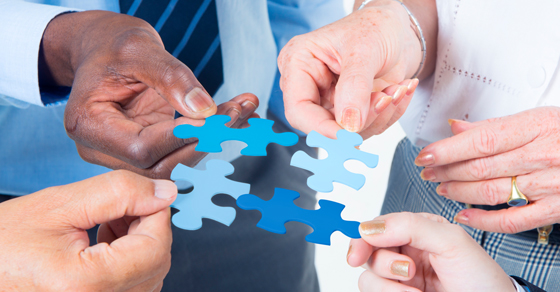 hands holding puzzle pieces toward each other