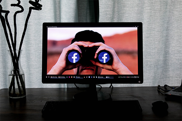 man looking through facebook binoculars