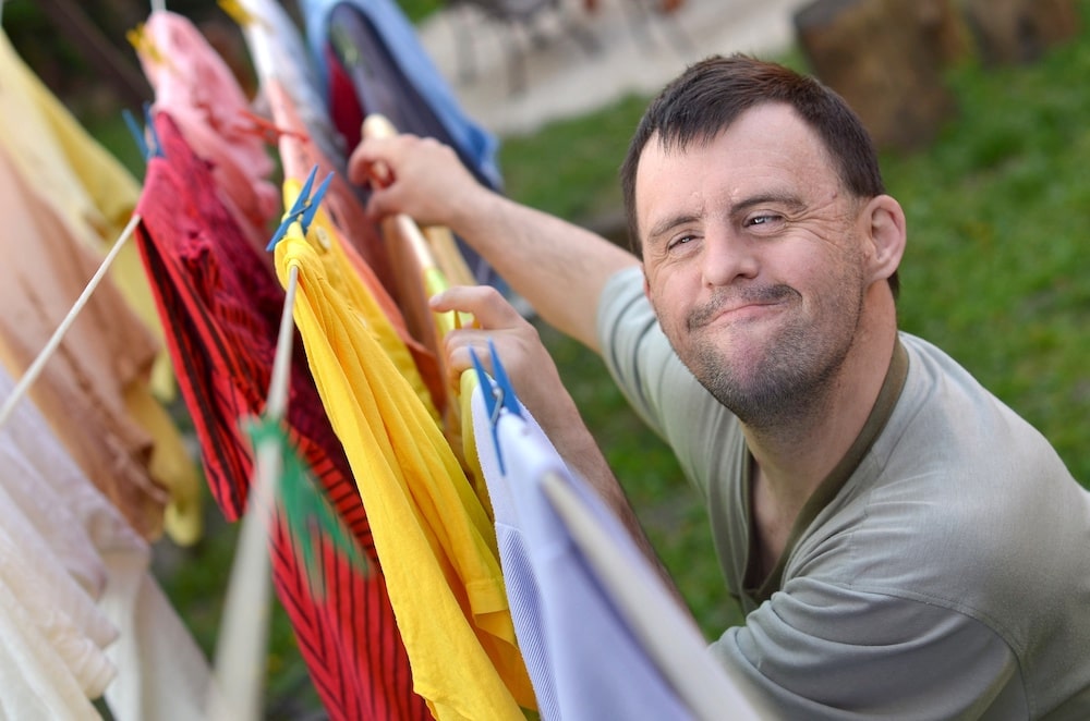 Adult male with down syndrome smiling outdoors