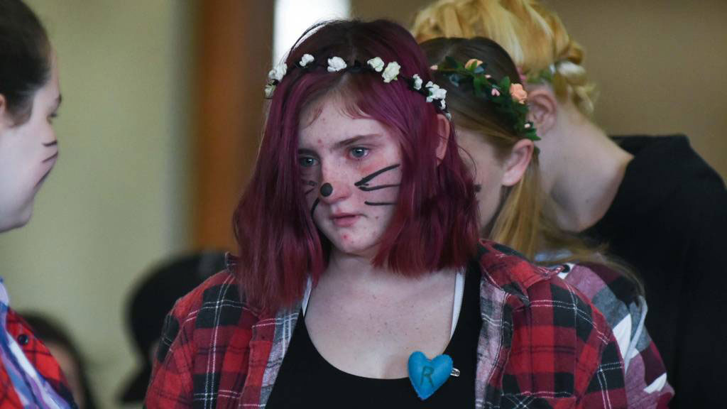 Mourner with heart pinned to chest