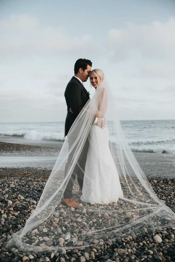bridge and groom smiling on beach