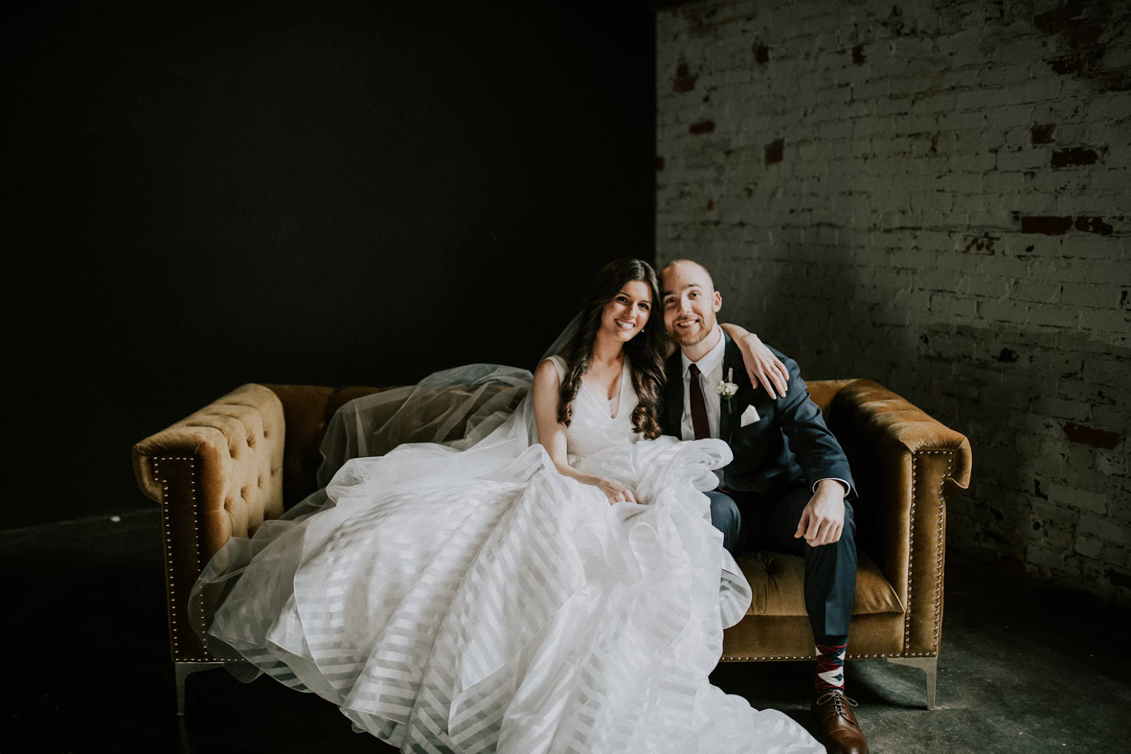 white bridge and groom sitting on brown sofa
