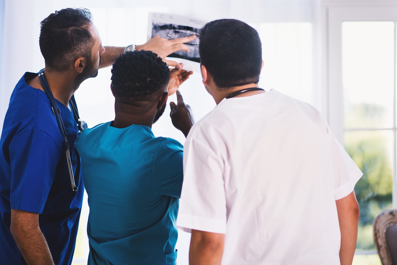 three male dentists looking at an x-ray