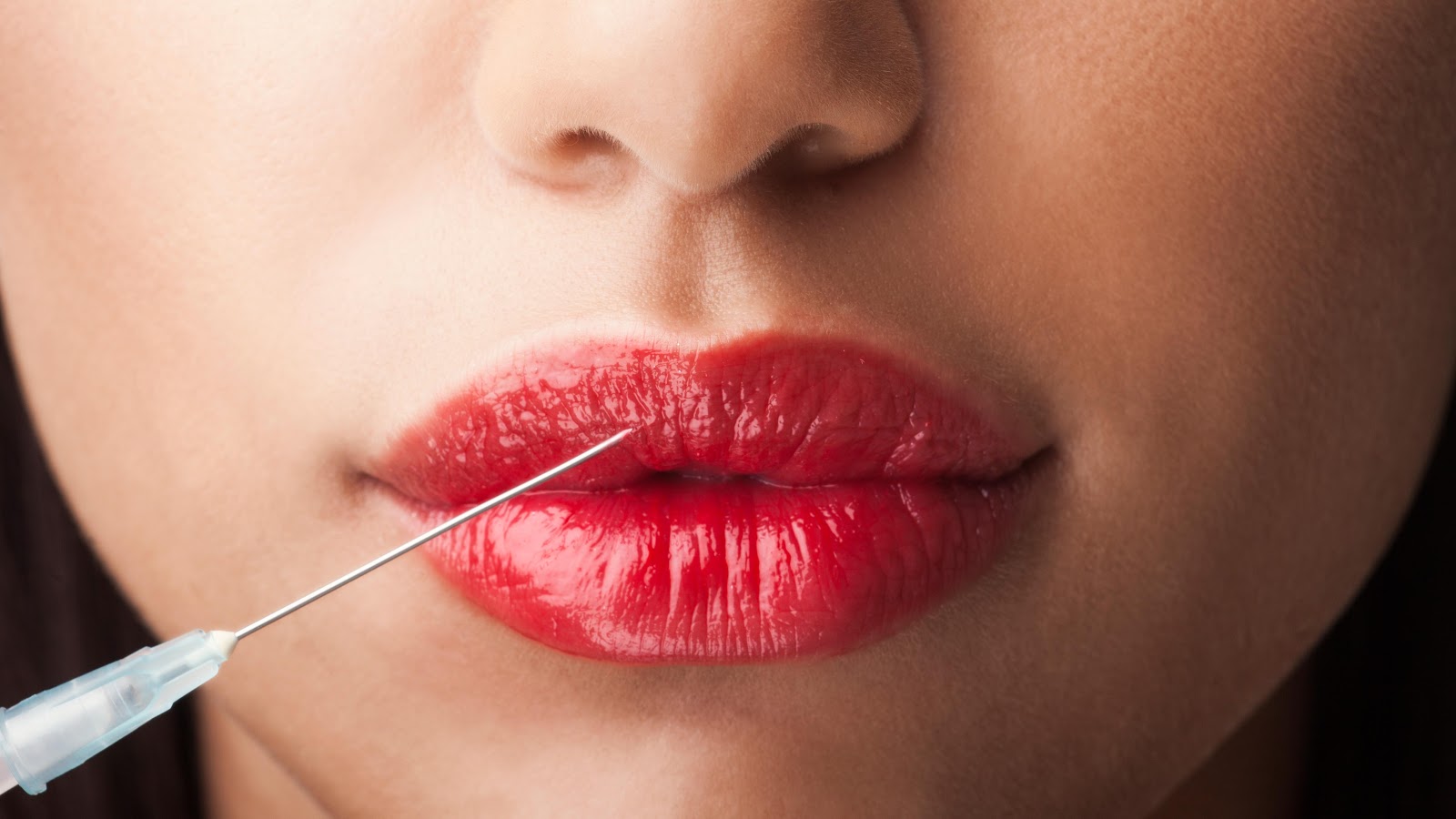 a woman sticking needle into her lips