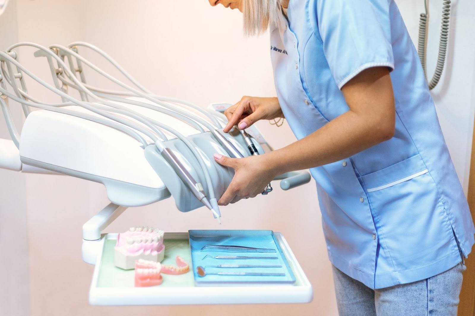 dental assistant standing in front of dental tray