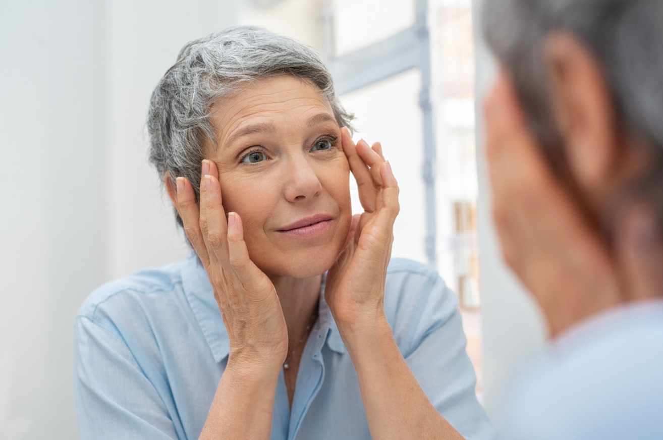 Older woman looking at her face in the mirror
