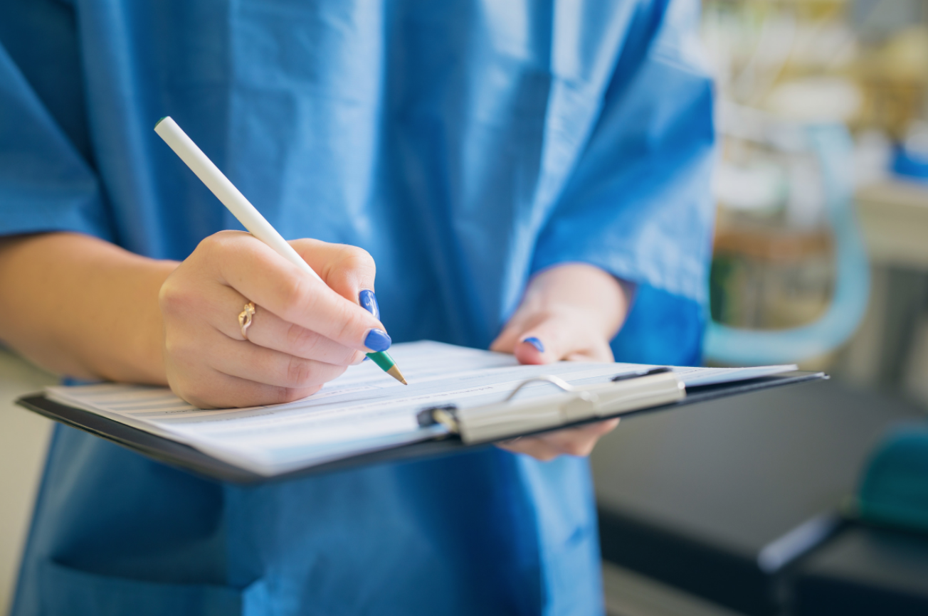 doctor writing on clipboard
