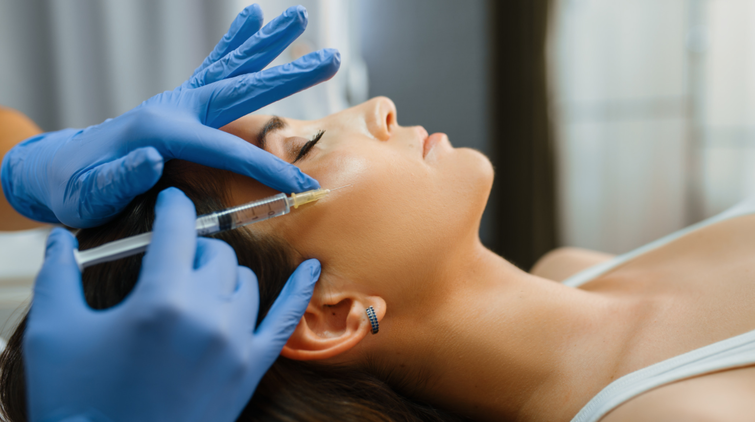 woman lying down getting cheek injected