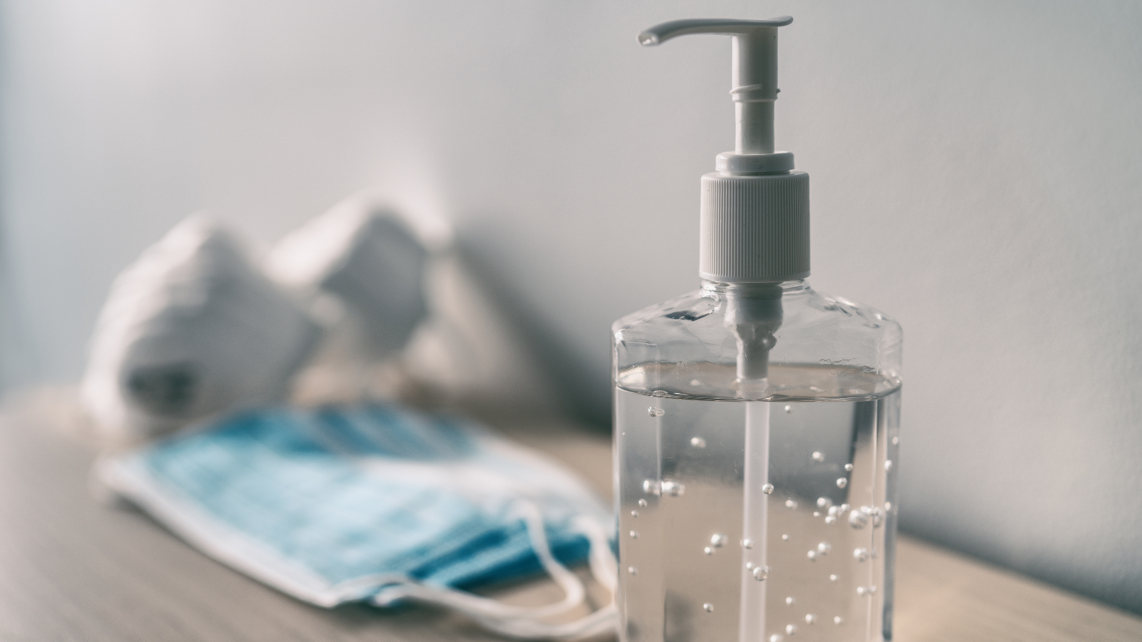 closeup of hand sanitizer and masks
