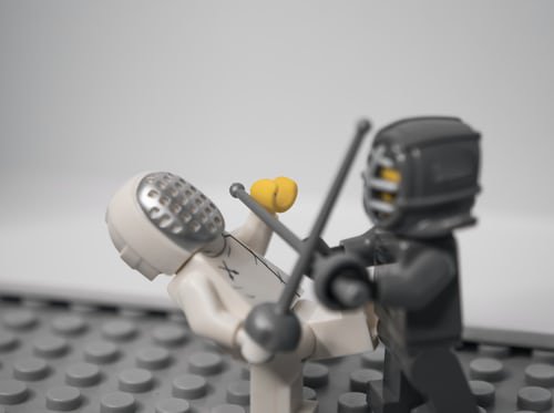 Two lego men sword fighting.