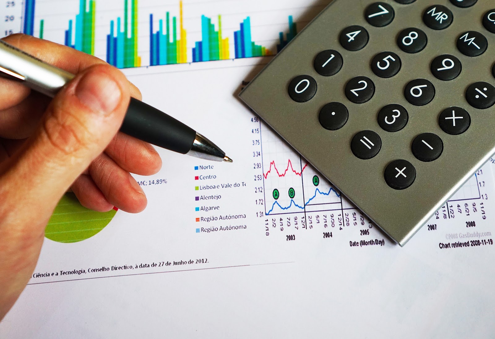 holding a gray pen chart and calculator