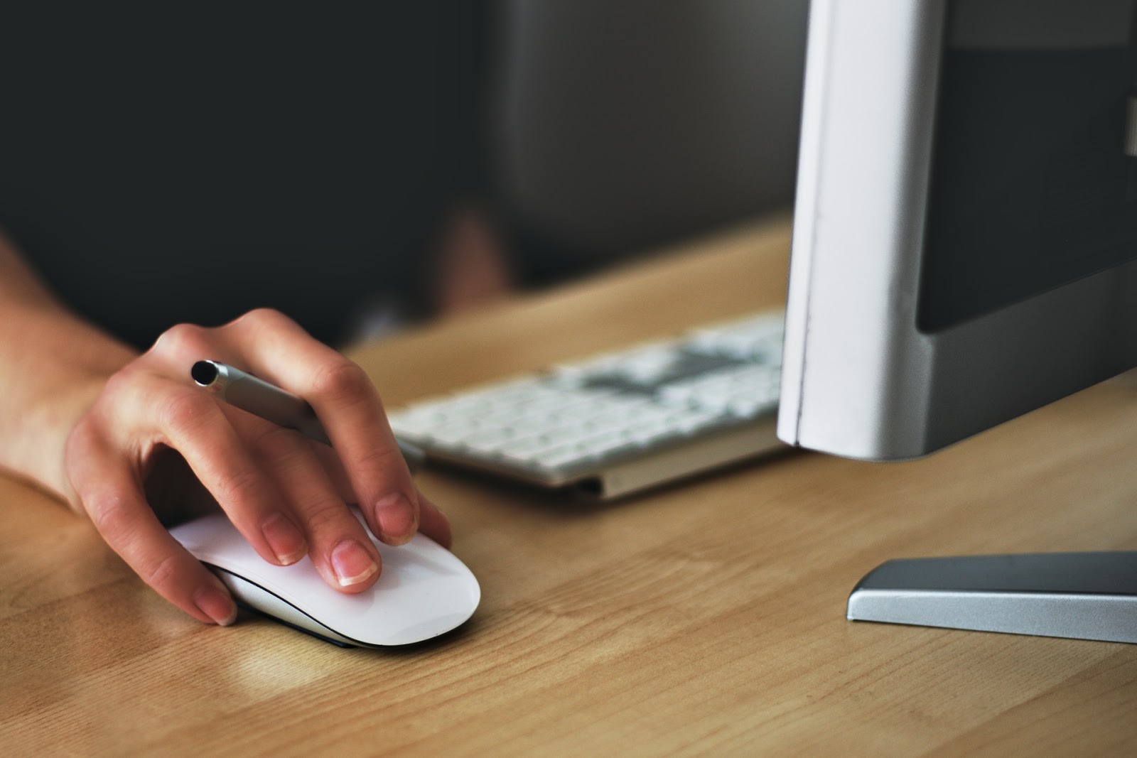 woman clicking a mouse on a desktop computer