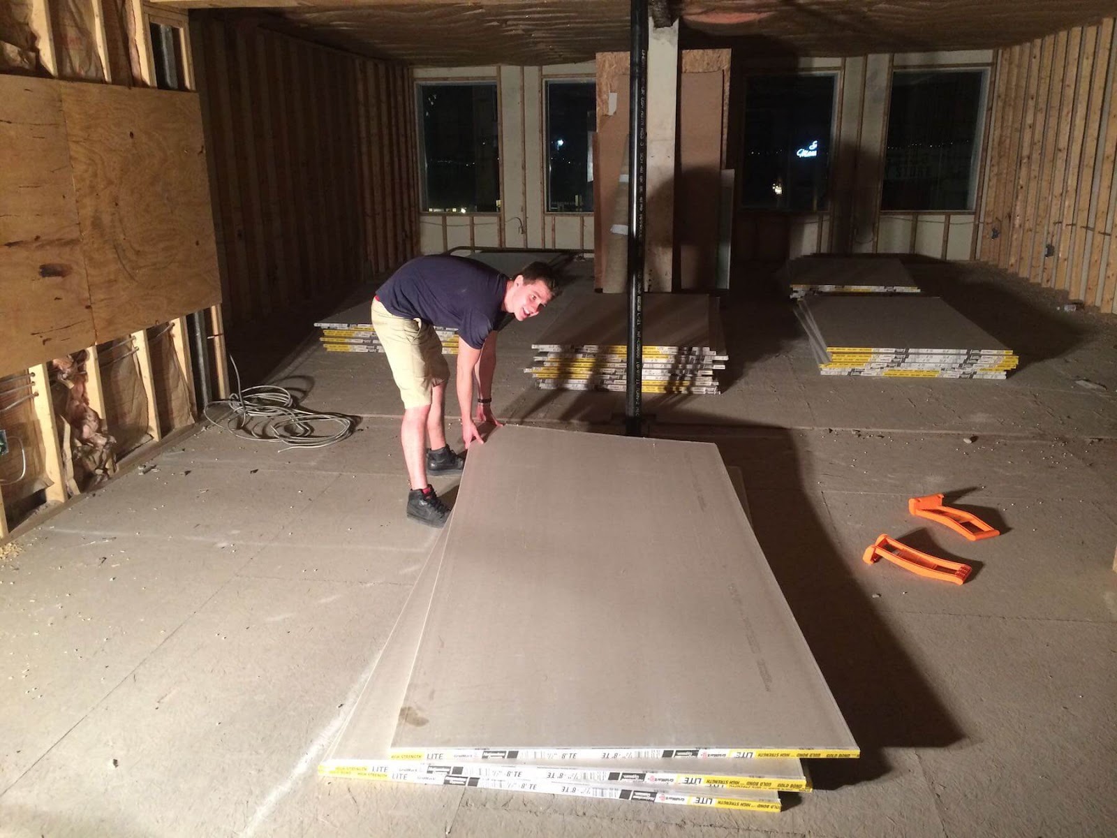 young man picking up drywall
