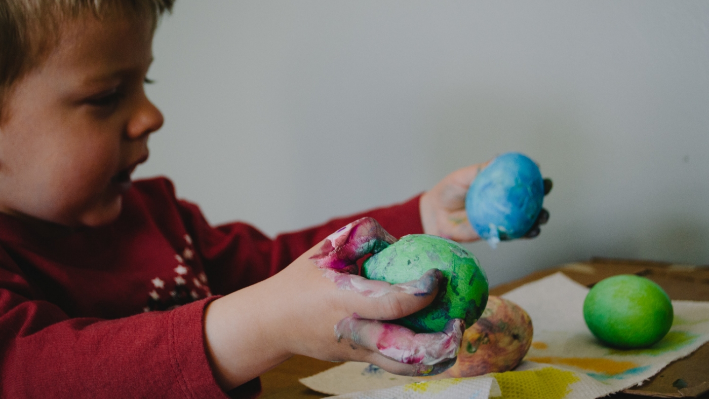 Kid painting easter eggs