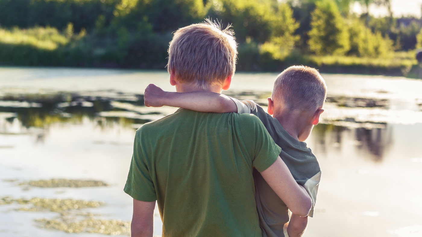 Two friends walking with a side hug