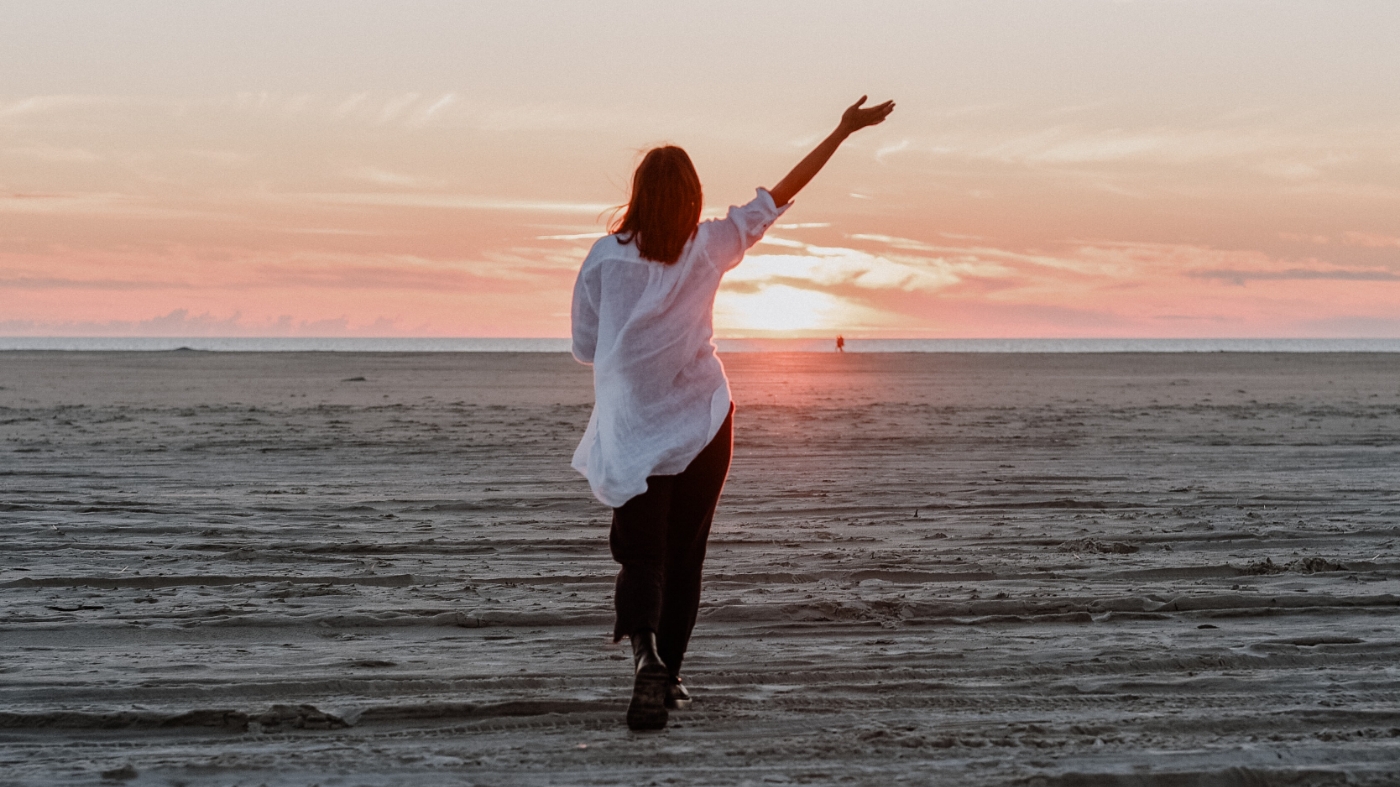 Woman praising god during beach sunset