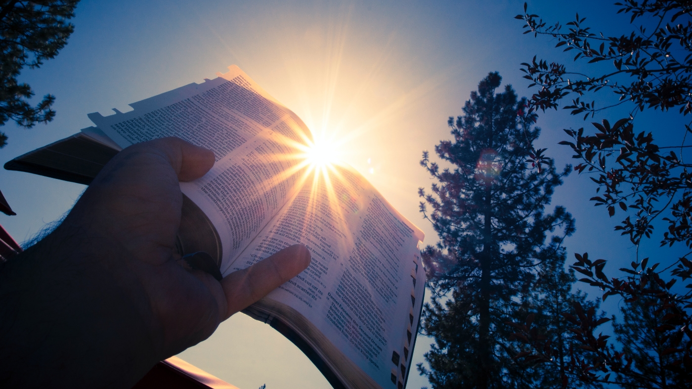 Holding up bible to the heavens
