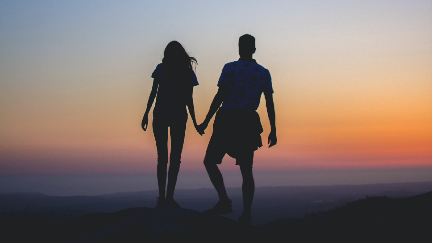 A couple that is in love holding hands during sunset