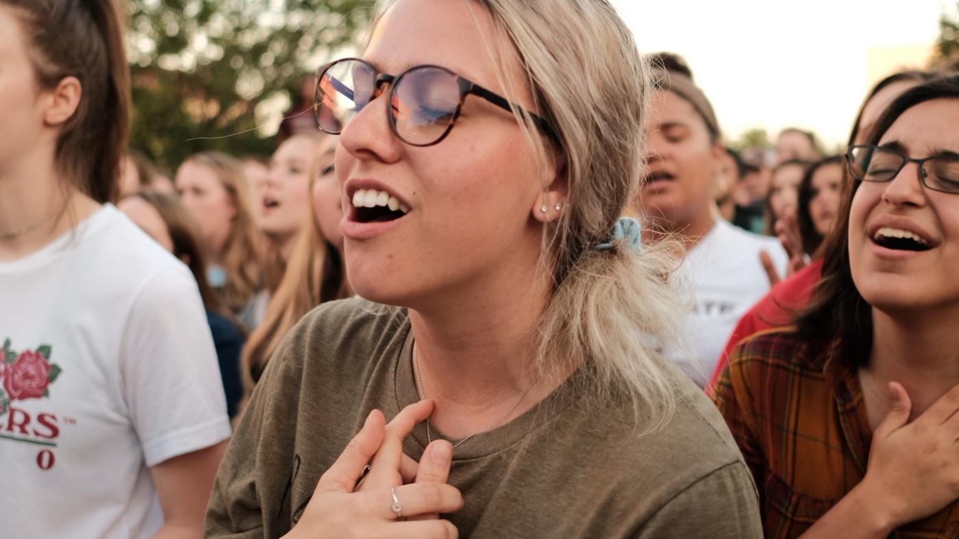 Girl singing in a group with her eyes closed