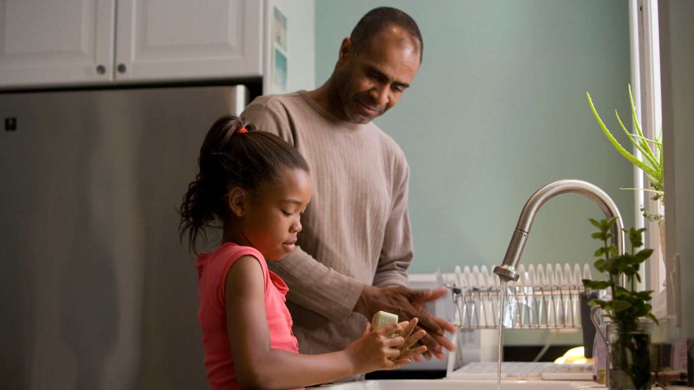 Father teaching her daughter how to wash